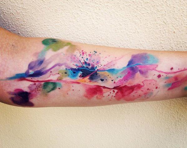 Bunte Aquarelltinte auf dem Unterarm